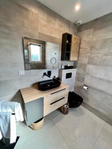 een badkamer met een wastafel en een spiegel bij jolie maison neuve au coeur des vignes in Cogolin