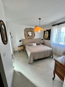 1 dormitorio con cama y espejo en la pared en jolie maison neuve au coeur des vignes en Cogolin