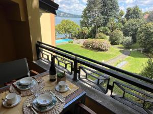 a table on a balcony with a view of the water at Sole e Lago in Stresa