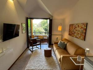 a living room with a couch and a television at Sole e Lago in Stresa