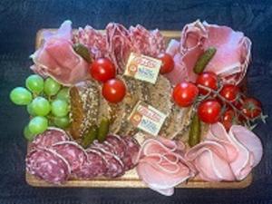 um tabuleiro de carnes e legumes com uvas e tomates em Vittoria Immobilier 5 - REGLEMENT SUR PLACE - chèques vacances acceptés em La Grande-Motte