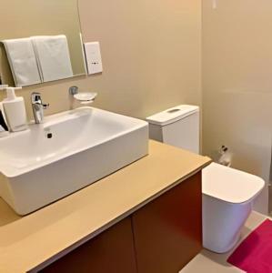 La salle de bains est pourvue d'un lavabo blanc et de toilettes. dans l'établissement Negombo Ocean Breeze Luxury Studio by Serendib Vacation, à Negombo