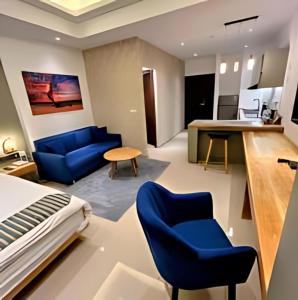 une chambre d'hôtel avec un lit et des chaises bleues dans l'établissement Negombo Ocean Breeze Luxury Studio by Serendib Vacation, à Negombo