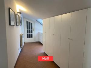 a hallway with white cabinets and a red sign that reads hell at Appartamento a 50m da Piazza Alfieri in Asti