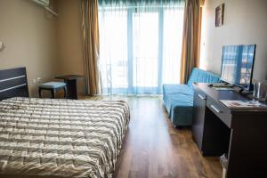 um quarto de hotel com uma cama e um sofá em Hotel Buena Vissta em Primorsko