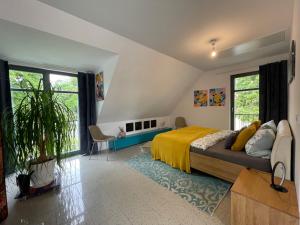 een slaapkamer met een groot bed en een gele deken bij Ferienhaus Ferienwohnung Potsdam DieGaLerie am Schlosspark Marquardt 