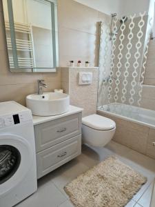a bathroom with a sink and a washing machine at Apartment Lučka in Rab