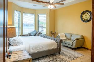 ein Schlafzimmer mit einem Bett, einem Sofa und einer Uhr in der Unterkunft Peaceful Luxurious Ranch Family Reunion in Wanette