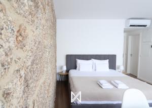a bedroom with a bed with two towels on it at MyStay - D Maria Apartments in Vila Nova de Famalicão