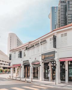 a white building on a street with tall buildings at Magazine Vista Hotel Managed by The Ascott Limited in George Town