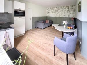 cocina y sala de estar con mesa y sillas. en Nisterlo Guesthouse, en Nistelrode