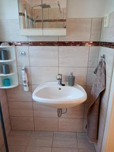 y baño con lavabo blanco y espejo. en Borostyán Vendégház Dunasziget, en Dunasziget