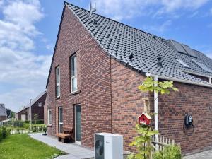 a red brick house with a black roof at Am Kutterhafen 17 - HAFENGLÜCK in Fedderwardersiel