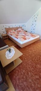 1 dormitorio con 1 cama y 1 mesa en una habitación en Nati és Bea Vendégház, en Hajdúszoboszló