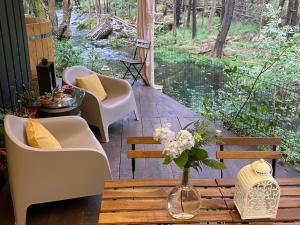 a porch with chairs and a table with a vase of flowers at Wild Glamping Portugal with hot tub to relax in Viana do Castelo in Viana do Castelo