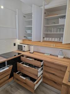 a kitchen with white cabinets and wooden drawers at Cozy apartment near beach in Gajac in Skunca