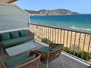 a balcony with chairs and a table and the beach at Alexandra 29 in Roses