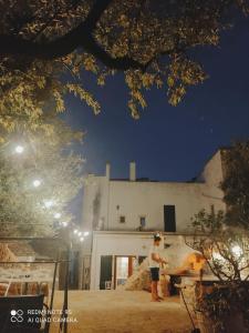 a person standing in front of a building at night at Masseria Calò in Monopoli
