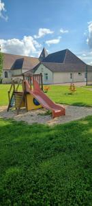 einen Spielplatz mit Rutsche im Gras in der Unterkunft Gite de la Bouvotte in Neuville-sur-Vanne