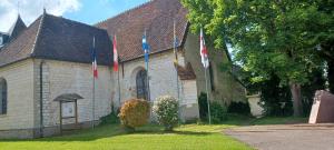 eine Kirche mit Flaggen davor in der Unterkunft Gite de la Bouvotte in Neuville-sur-Vanne