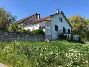 a white house on a hill with a stone wall at Au Pré de Karine in Cunèges