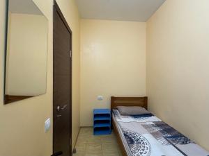 ein kleines Schlafzimmer mit einem Bett und einem Spiegel in der Unterkunft Sun in Chmelnyzkyj
