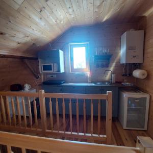 una cocina en una cabaña de madera con fregadero y barra en Apartmány U Tří Sluncí, en Hroubovice