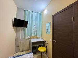 Zimmer mit einem Bett, einem Schreibtisch und einem Fenster in der Unterkunft Sun in Chmelnyzkyj