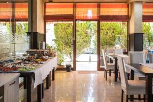 a restaurant with tables and chairs with food on them at Hotel Buena Vissta in Primorsko