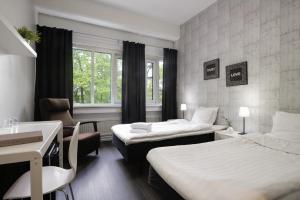 Habitación de hotel con 2 camas y lavamanos en Hotel CityHovi, en Rauma