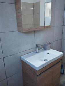 bagno con lavandino bianco e specchio di Vangelis House near Athens Airport a Artemida