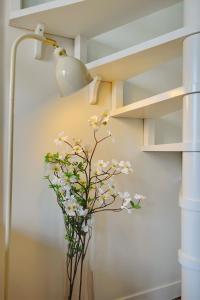 a vase with flowers in a room with a lamp at Cosy Duplex in Boulogne-Billancourt +5 photos