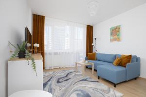 sala de estar con sofá azul y TV en Apartments Dexter Warsaw by Renters, en Varsovia