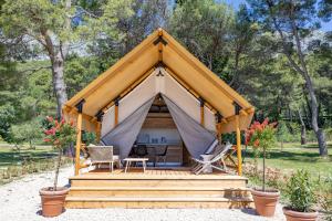 Glamping & Holiday Home experience - Camp Dole في زيفوغوشي: شرفة مع طاولة وكراسي في غابة