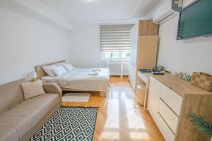a living room with a couch and a bed at Apartman Lumi in Čakovec