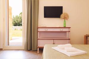 1 dormitorio con vestidor y TV en la pared en Agriturismo Le Site, en Corigliano d'Otranto