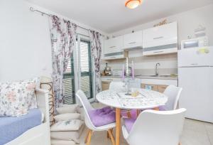 a kitchen with a table and chairs in a kitchen at New! Apartment Aenona 200m from the beach, Nin in Nin