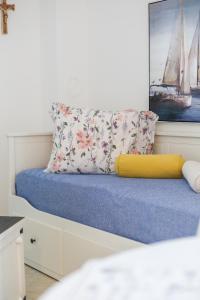 a bed with a yellow pillow and a painting at New! Apartment Aenona 200m from the beach, Nin in Nin