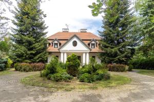 a white house with a red roof at Apartamenty w Dworku Cheval in Kraków