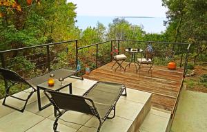 una terrazza in legno con tavolo e sedie. di Maramare Pinus a Stara Baška