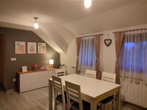 a kitchen and dining room with a table and chairs at Apartment Lana in Rakovica