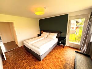 1 dormitorio con cama y ventana grande en Haus am Bodensee, en Fußach
