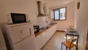 a kitchen with a tv on top of a refrigerator at Yaki Home in Arucas