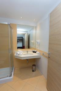 a bathroom with a sink and a mirror at HOTEL DON CAMILLO in Brescello