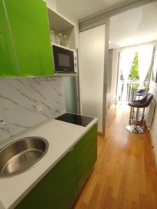 eine grüne und weiße Küche mit einem Waschbecken in der Unterkunft Bella vista - cozy apartment with a great view in Split