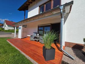 eine Holzterrasse vor einem Haus in der Unterkunft Ferienwohnung Jenny Edersee in Edersee