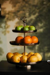 una vitrina de frutas de tres niveles con peras y naranjas en First Hotel Grand Falun en Falun