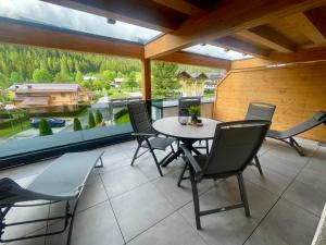 a patio with a table and chairs on a balcony at Sonnenseite Filzmoos in Filzmoos