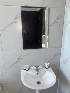 a white sink in a bathroom with a mirror at 2D Fantastic Villa Best HomeStay in Kampong Alor Gajah