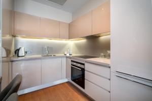 una cocina con armarios blancos y fregadero en Sentire Hotels & Residences, en Estambul